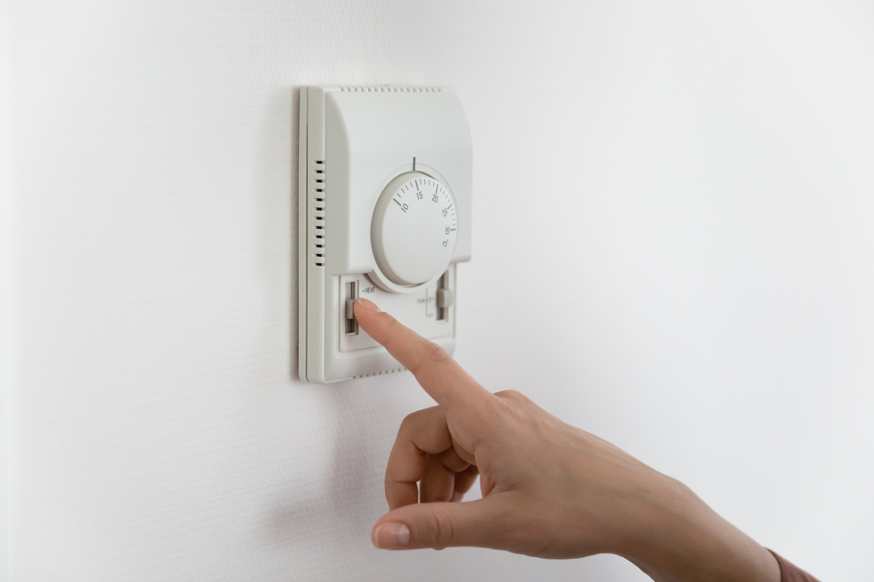 Close up of woman adjust temperature on air conditioner