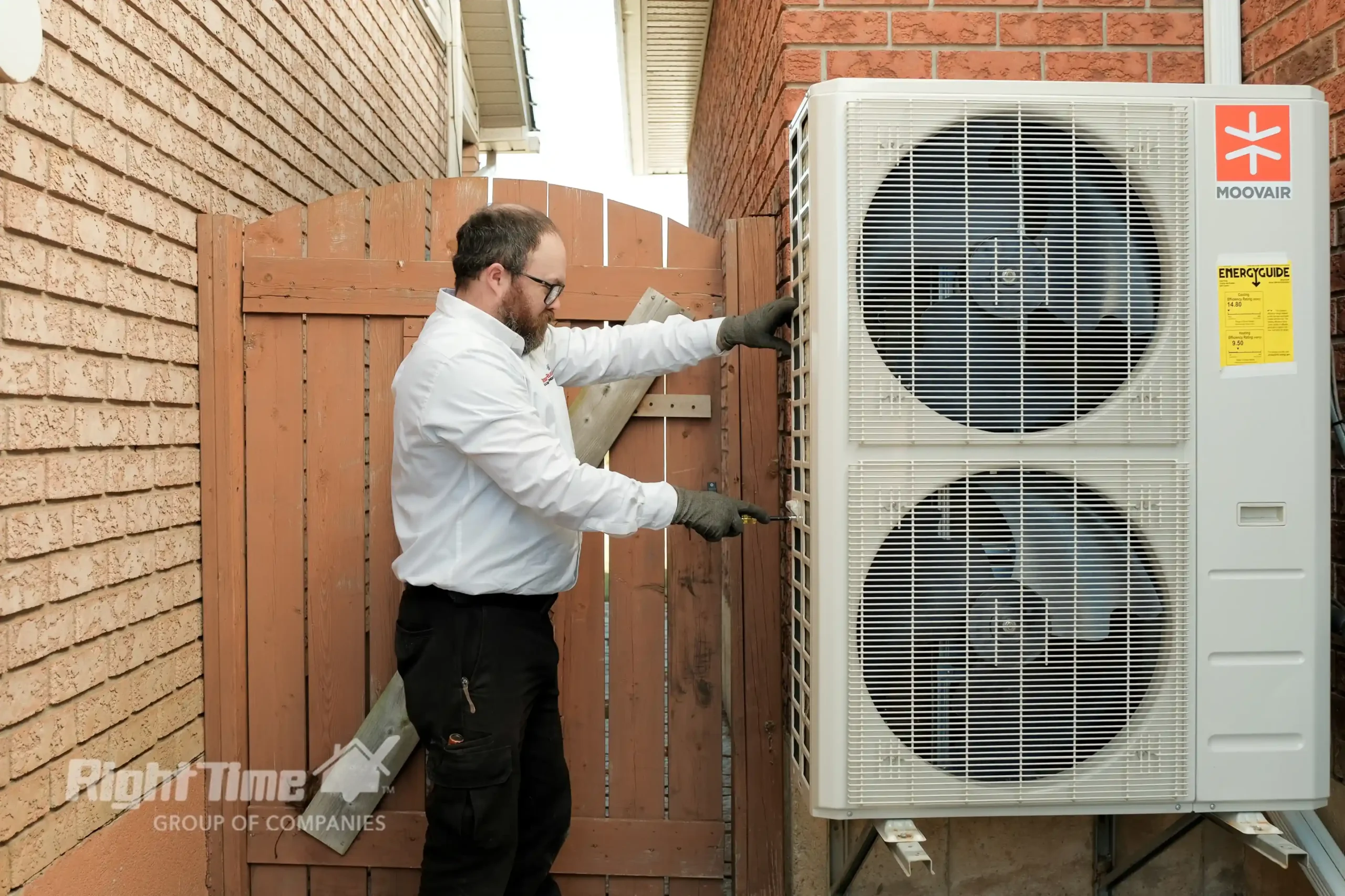 Technician reviewing a home’s furnace and heat pump setup to help choose the best heating option before Ontario’s winter.