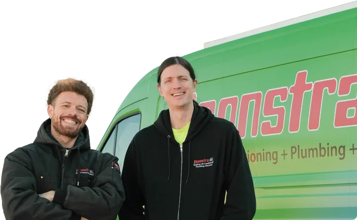 A Boonstra crew members in branded workwear smiling beside their green service van, promoting reliable plumbing and HVAC expertise.